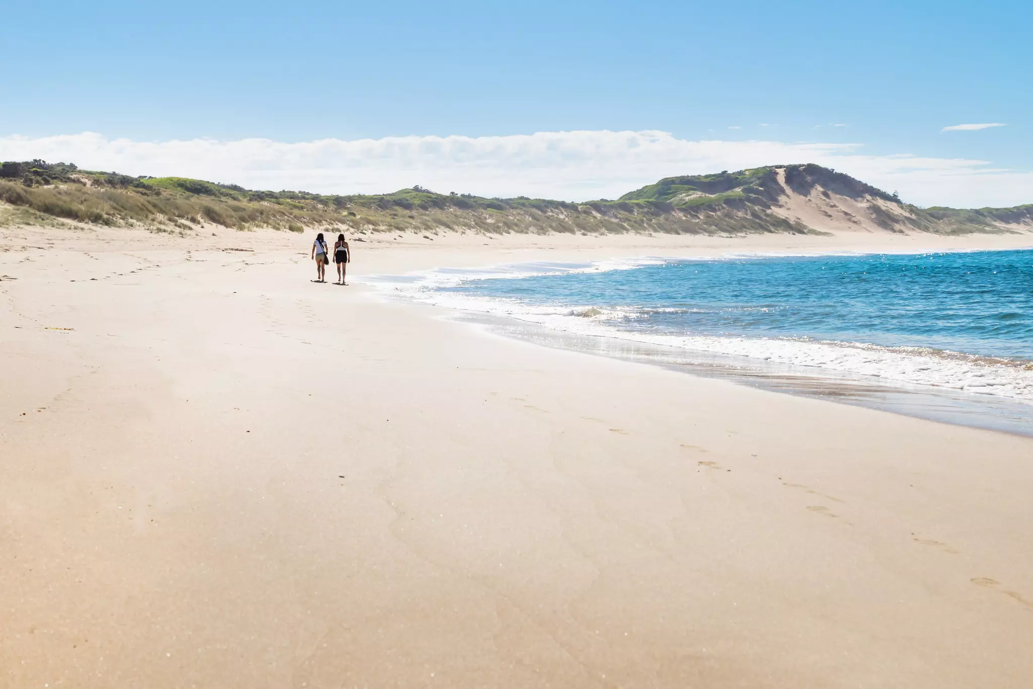 Victoria, Australia - two walkers at the beach of Peterborough at the Great Ocean Road in the morning