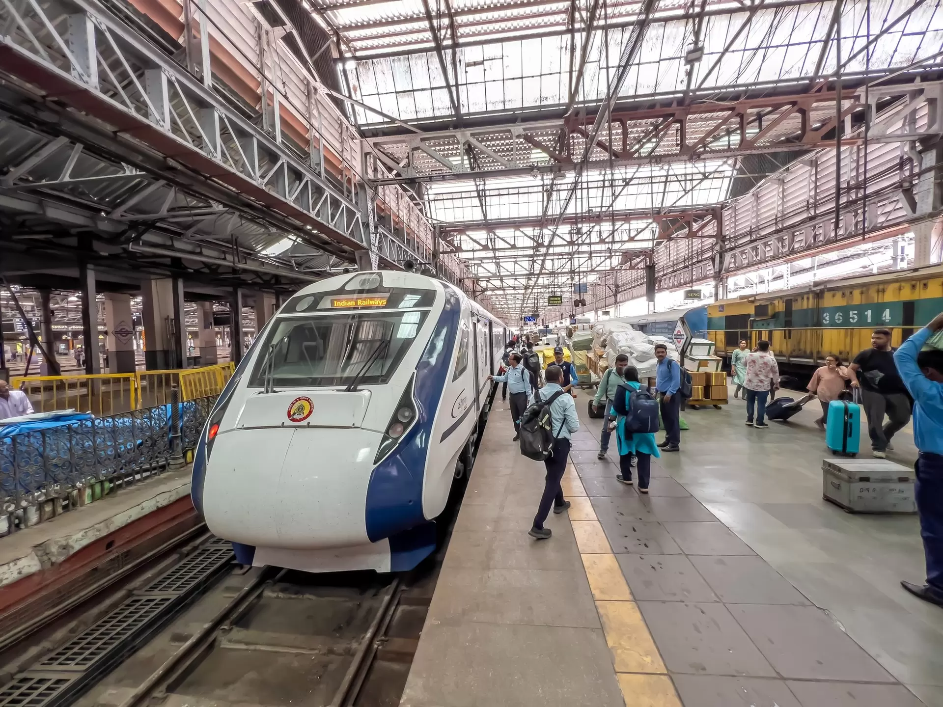 Passengers by a high-speed train at Mumbai's Chhatrapati Shivaji Maharaj Terminus, India.