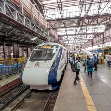 Passengers by a high-speed train at Mumbai's Chhatrapati Shivaji Maharaj Terminus, India.