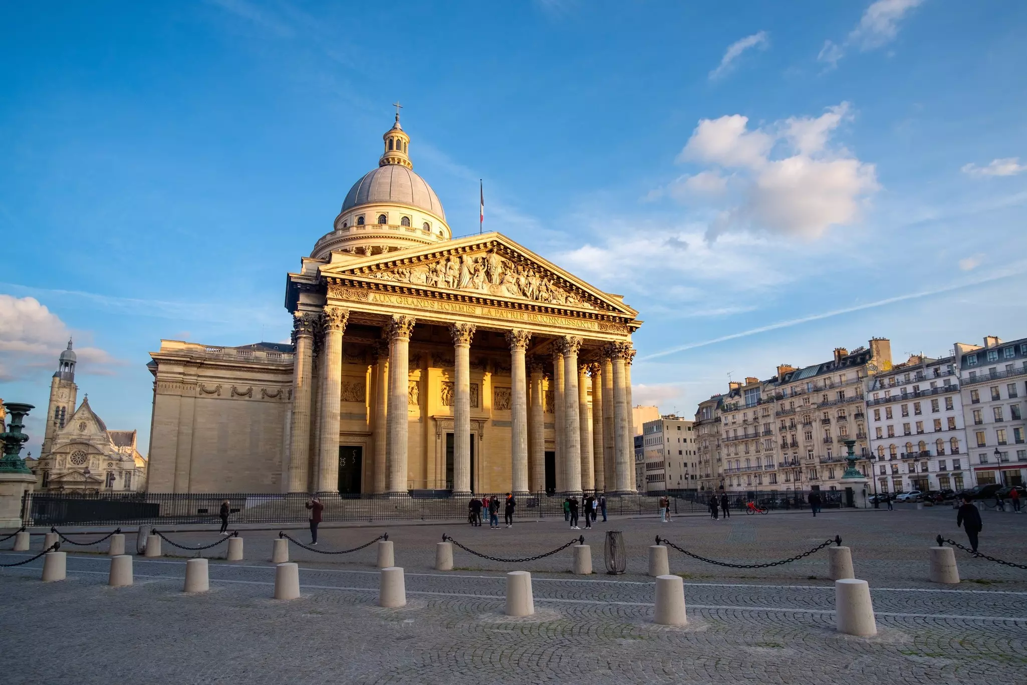 A large domed church with a columned facade in an elegant city square.