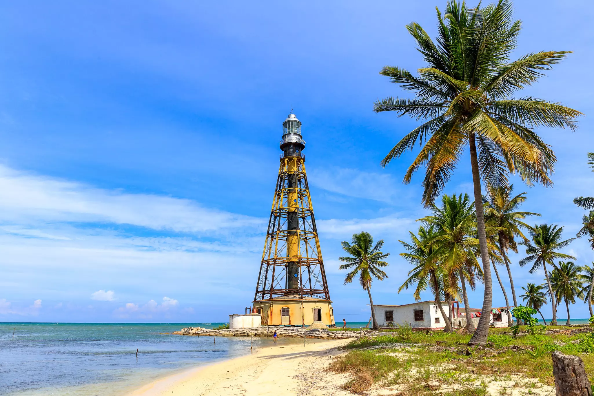 A lighthouse and palm trees dot the coast of Cayo Jutias on Cuba.