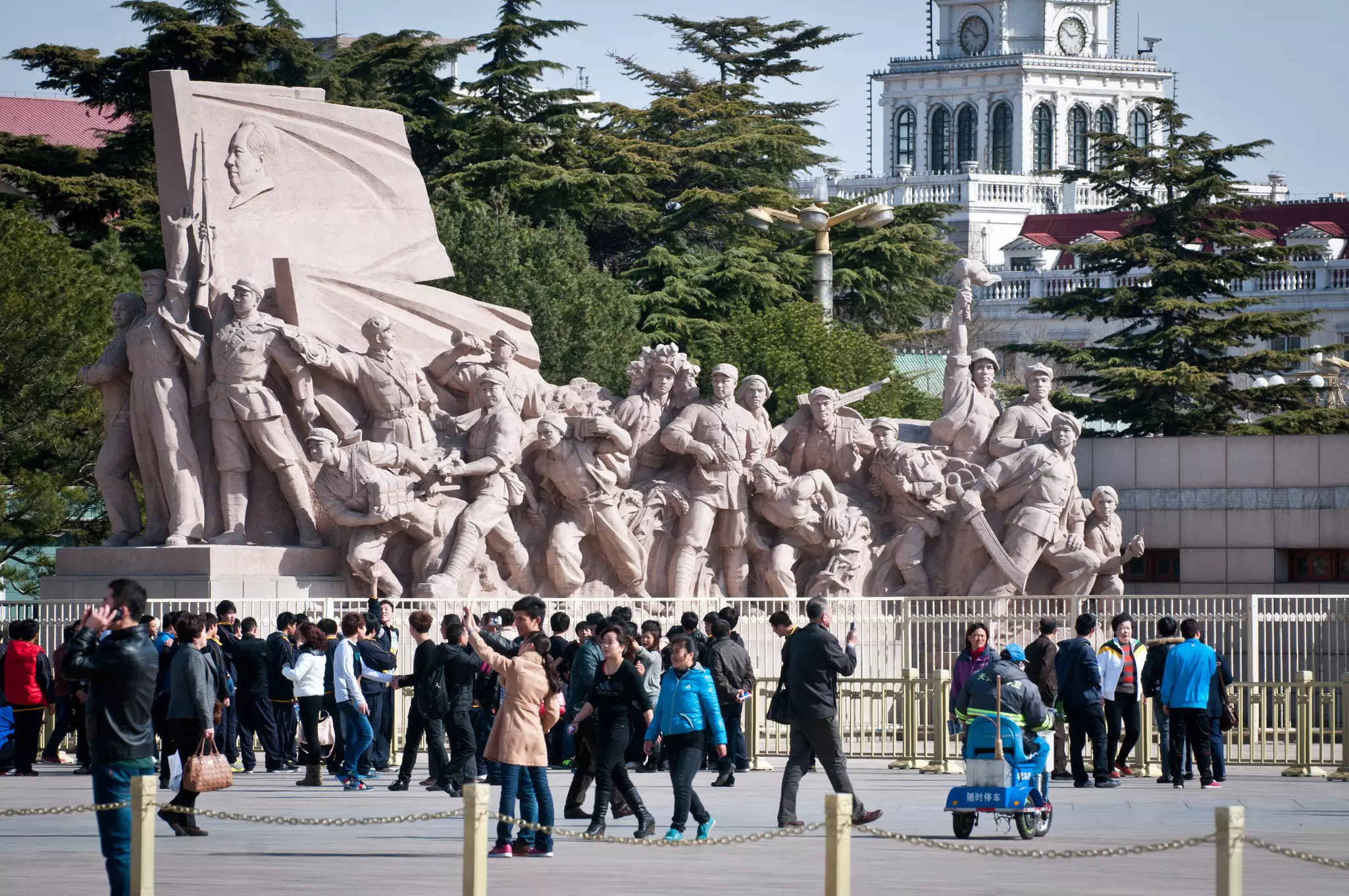 Visitors in front of a revolutionary statue next to the Chairman Mao Memorial Hall in Tiananmen Square, Beijing, China.