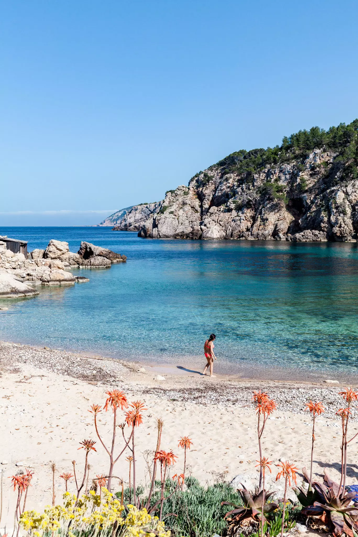 A woman checks the water at a secluded swimming cove