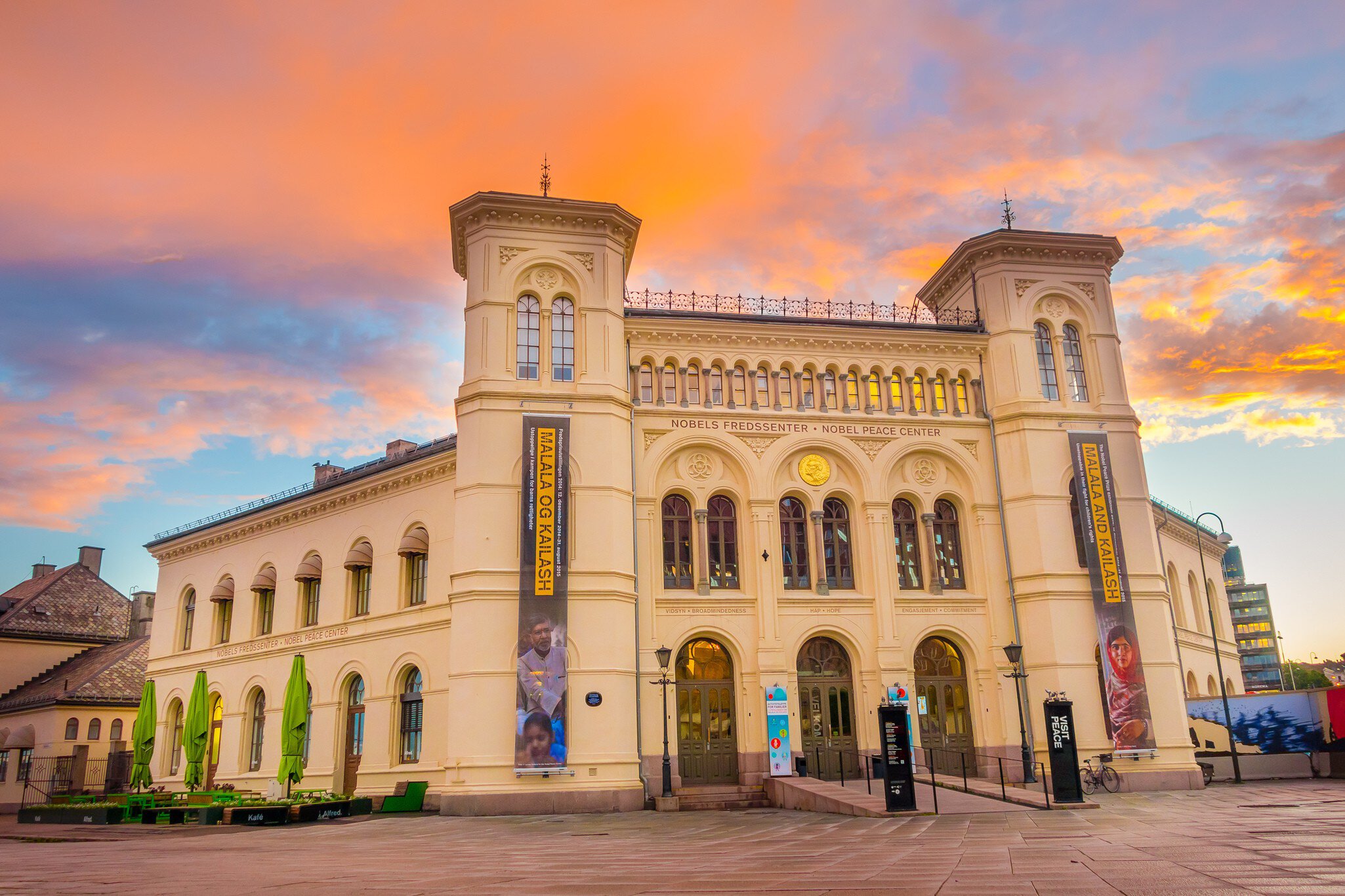 Cream neoclassical building with twin towers and exhibition banners at dusk
