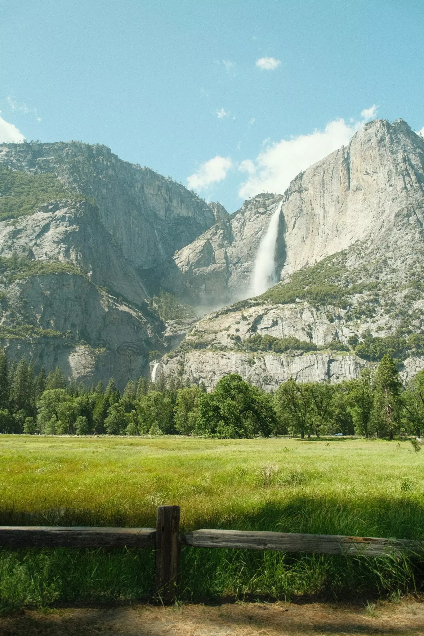 Yosemite National Park in California’s Sierra Nevada mountains green foliage on sunny day with waterfall,