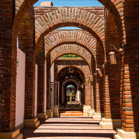 A path lined with brick columns and spanned by brick archways