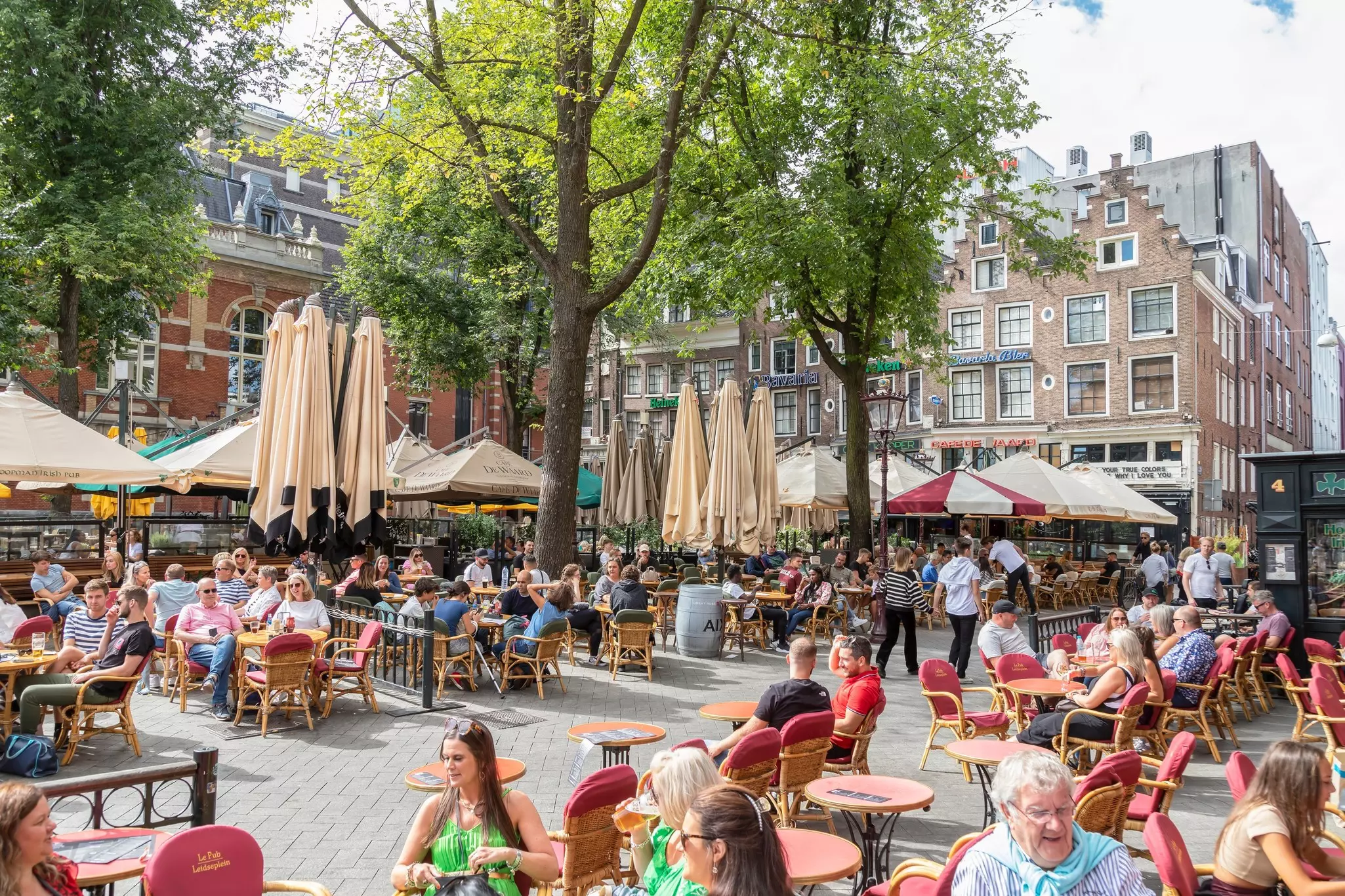 People eating at outside tables in Leidseplein in Amsterdam.