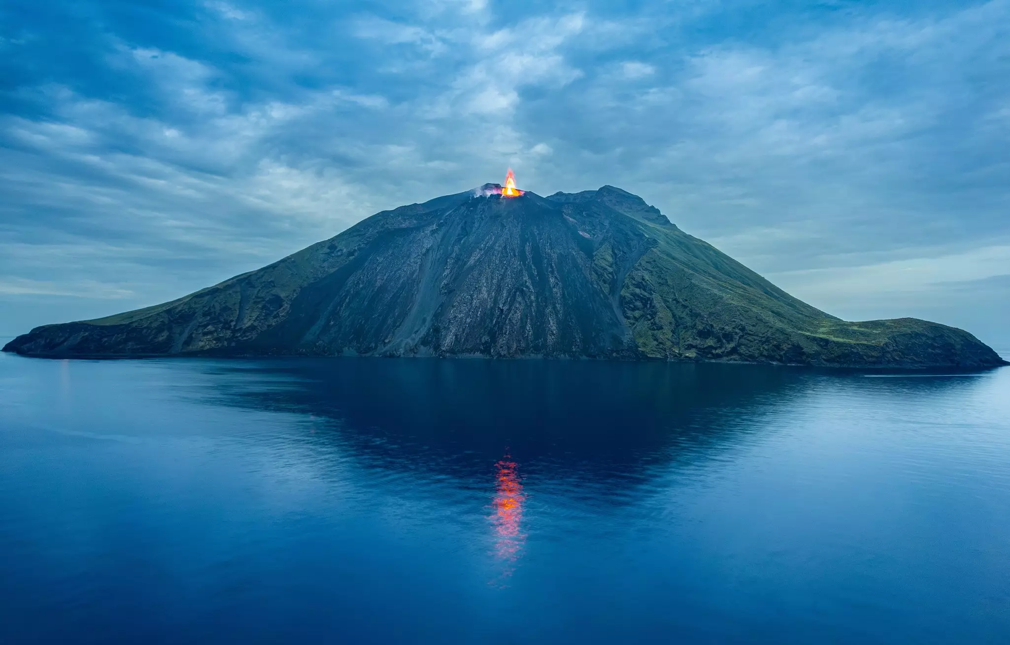 Stromboli volcano erupting off the coast of Italy at night time.