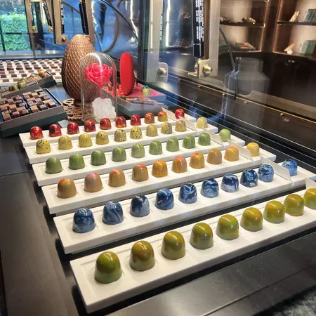 Rows of colorful domed chocolates on a tray.