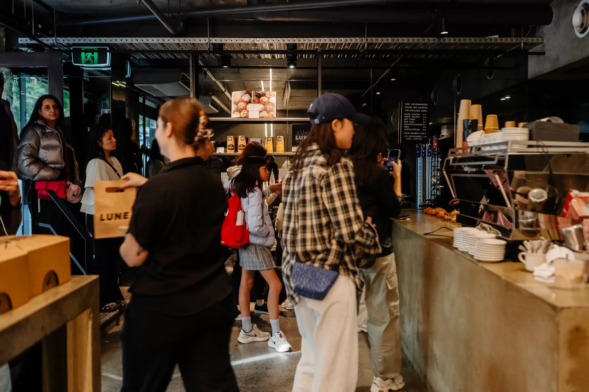 Melburnians queuing at a bakery in wintery clothes