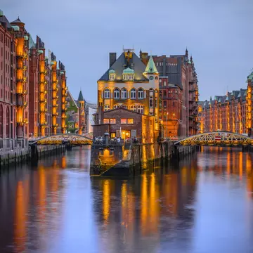 Hamburg city of warehouses at night with lights reflecting on the River Elbe