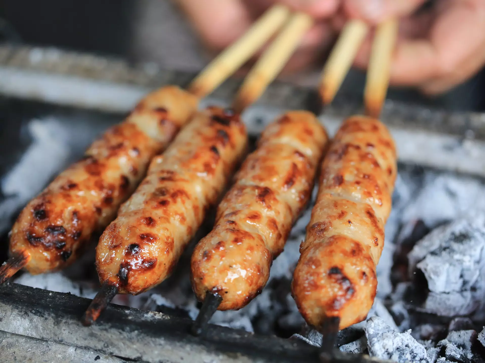A hand holding a bamboo weaving handbag by Shang Xia