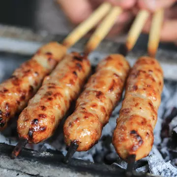 A hand holding a bamboo weaving handbag by Shang Xia