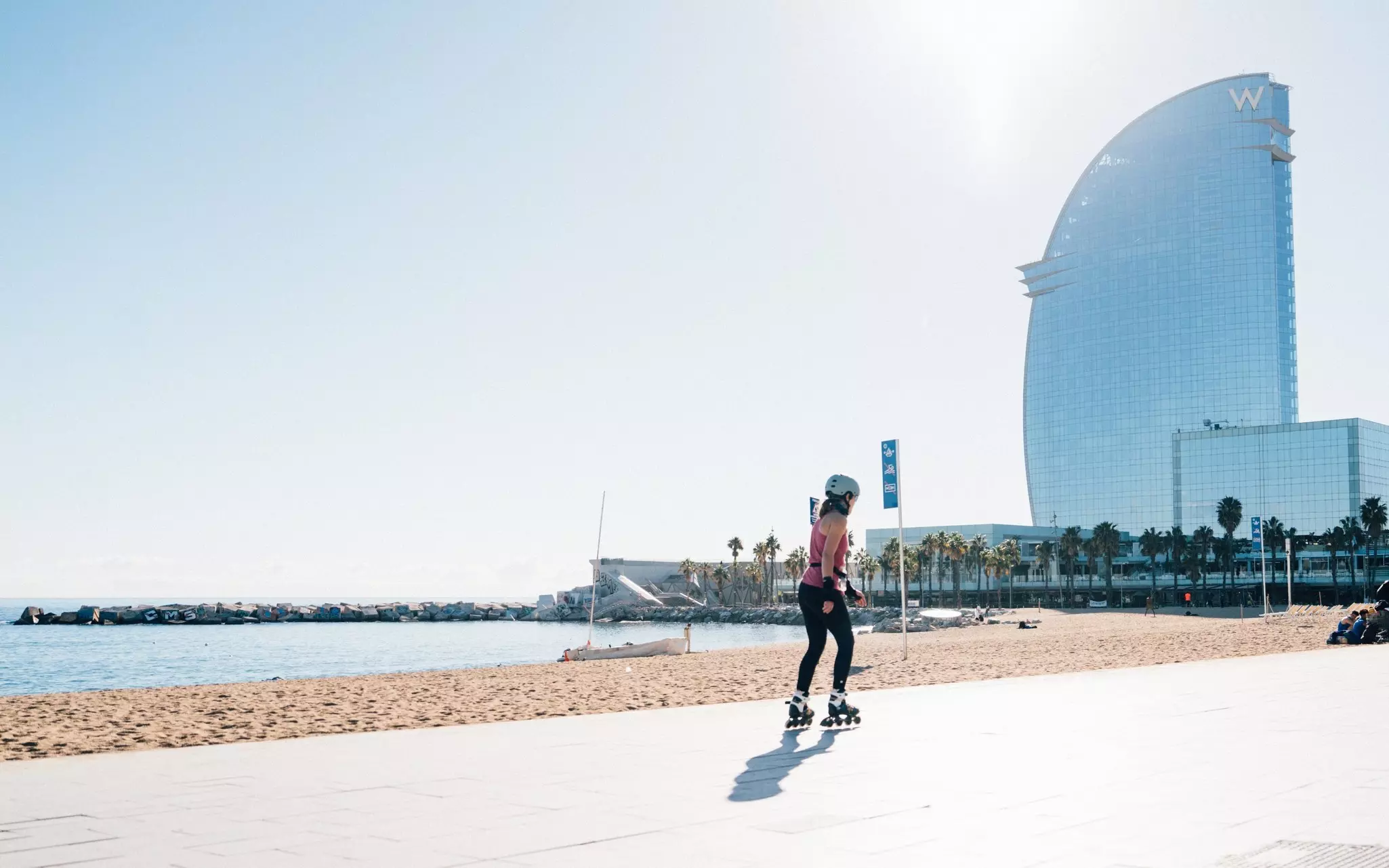 A young girl rollerblading along the Barceloneta beach in Barcelona