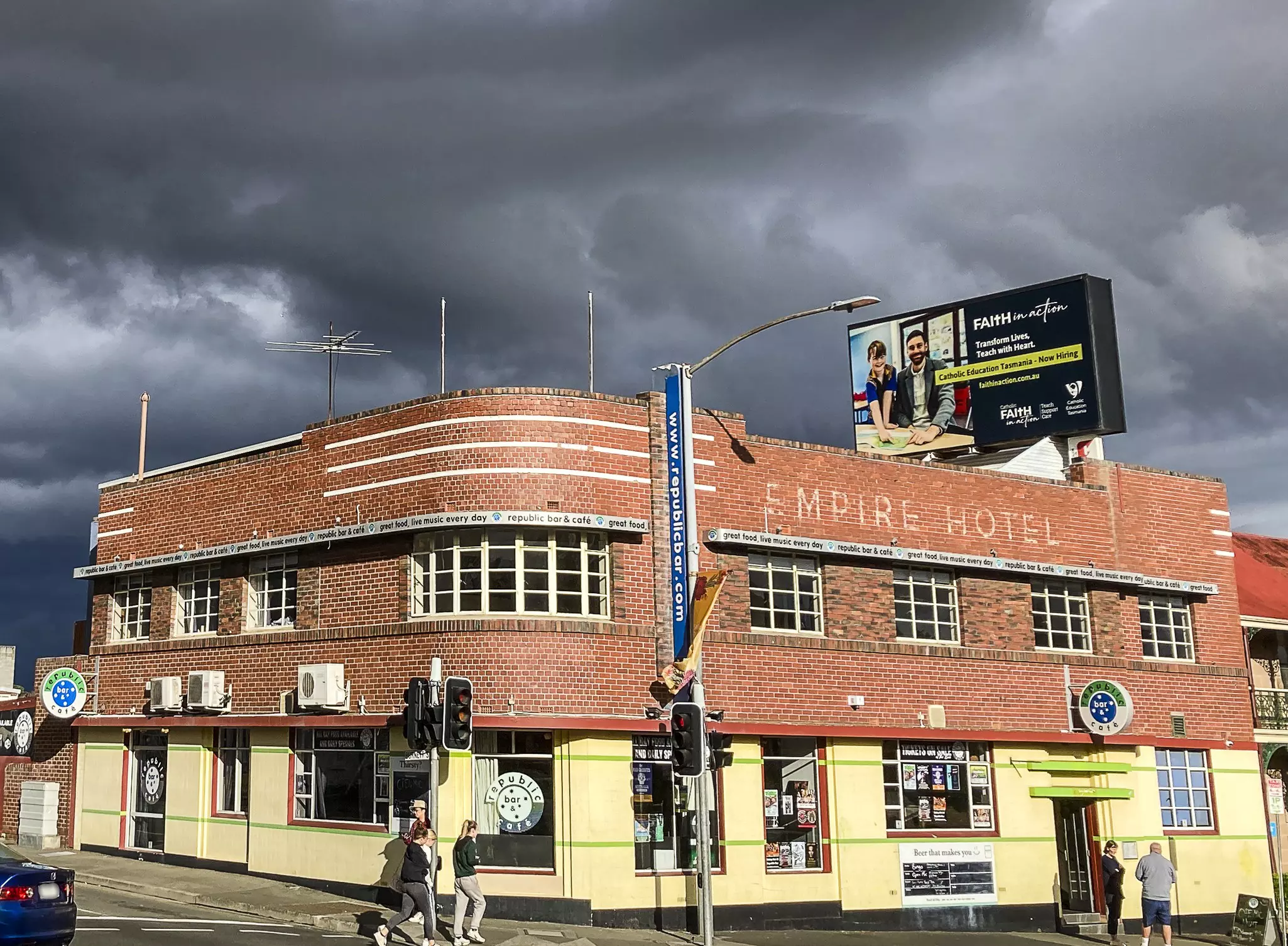 A faded yellow hanger-looking building with curved roof has a large blue sign reading 'blue bird garage'.