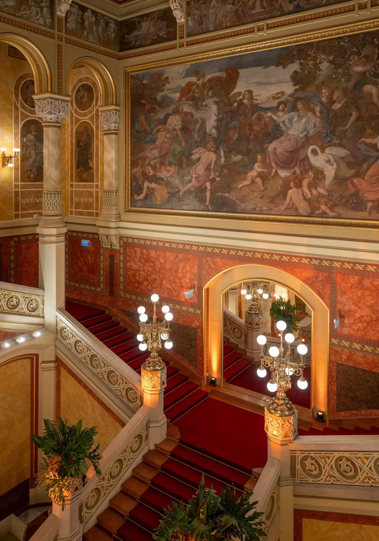 View of the stone staircase and murals by Mór Thán and Károly Lotz inside the Pesti Vigadó concert hall in Budapest, Hungary.