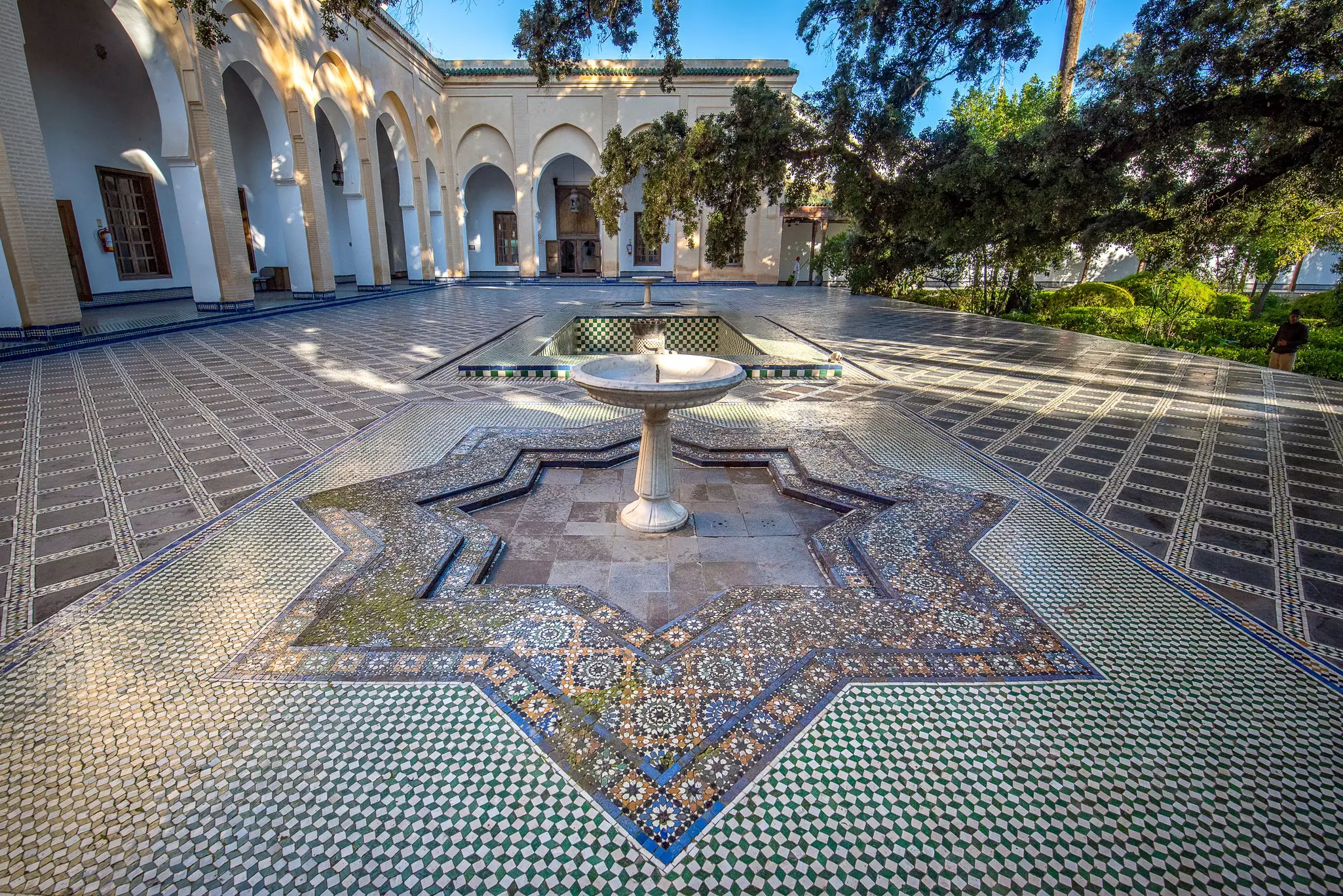 An intricately tiled courtyard with a central fountain.