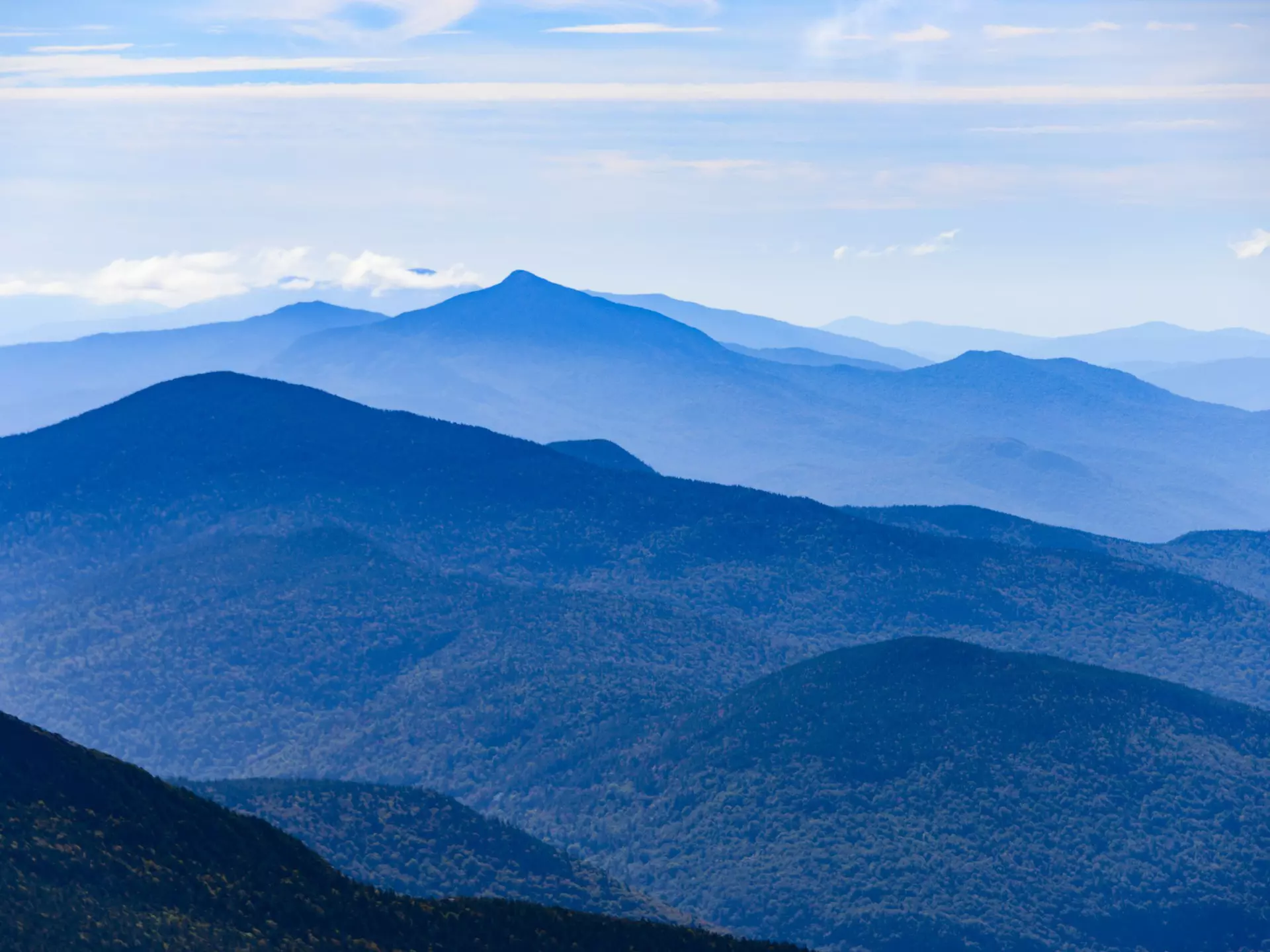 A mountain range in shades of green and blue