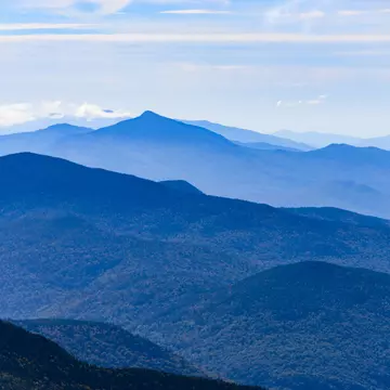A mountain range in shades of green and blue