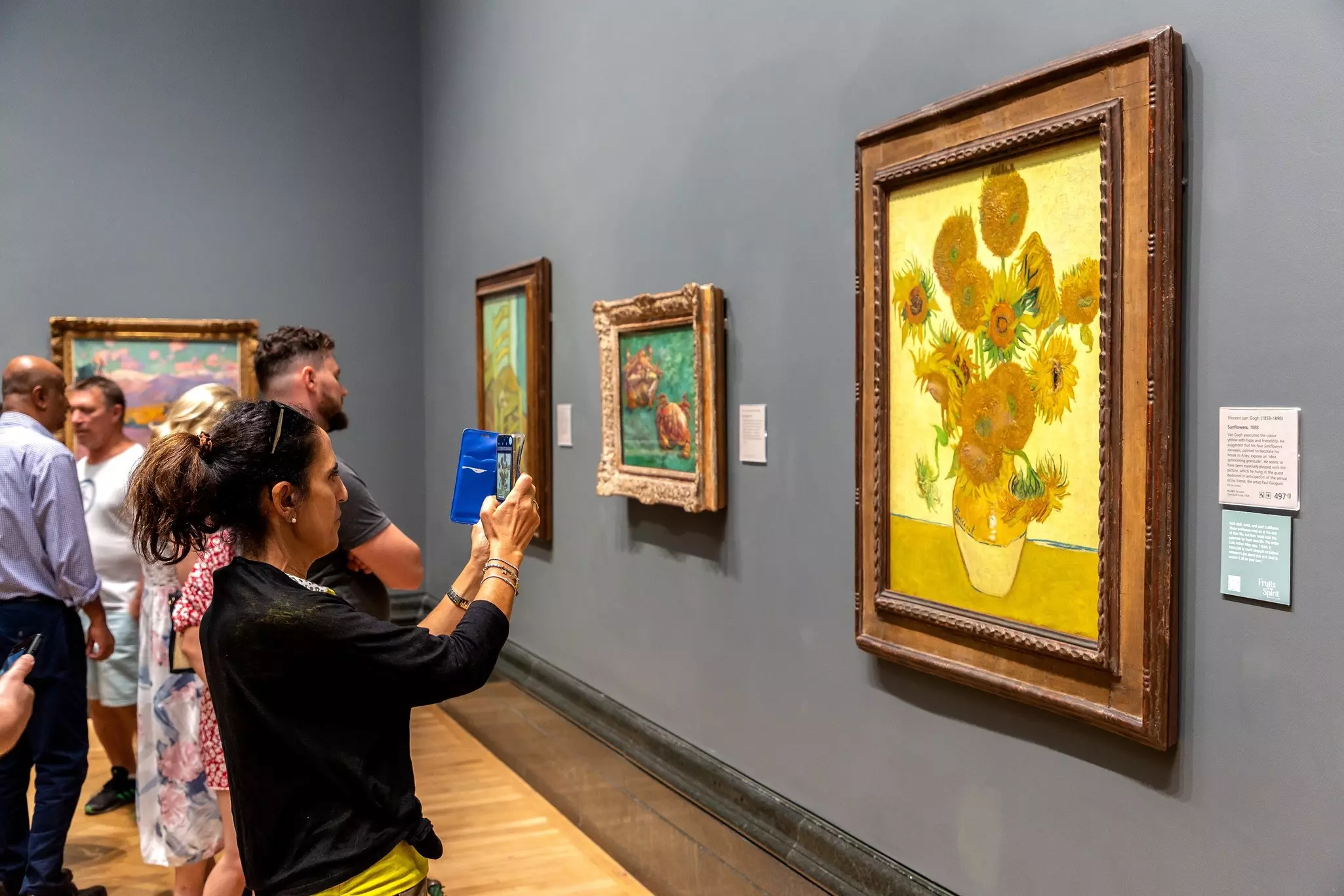Visitors look at “Sunflowers” by Vincent van Gogh at the National Gallery, London, UK