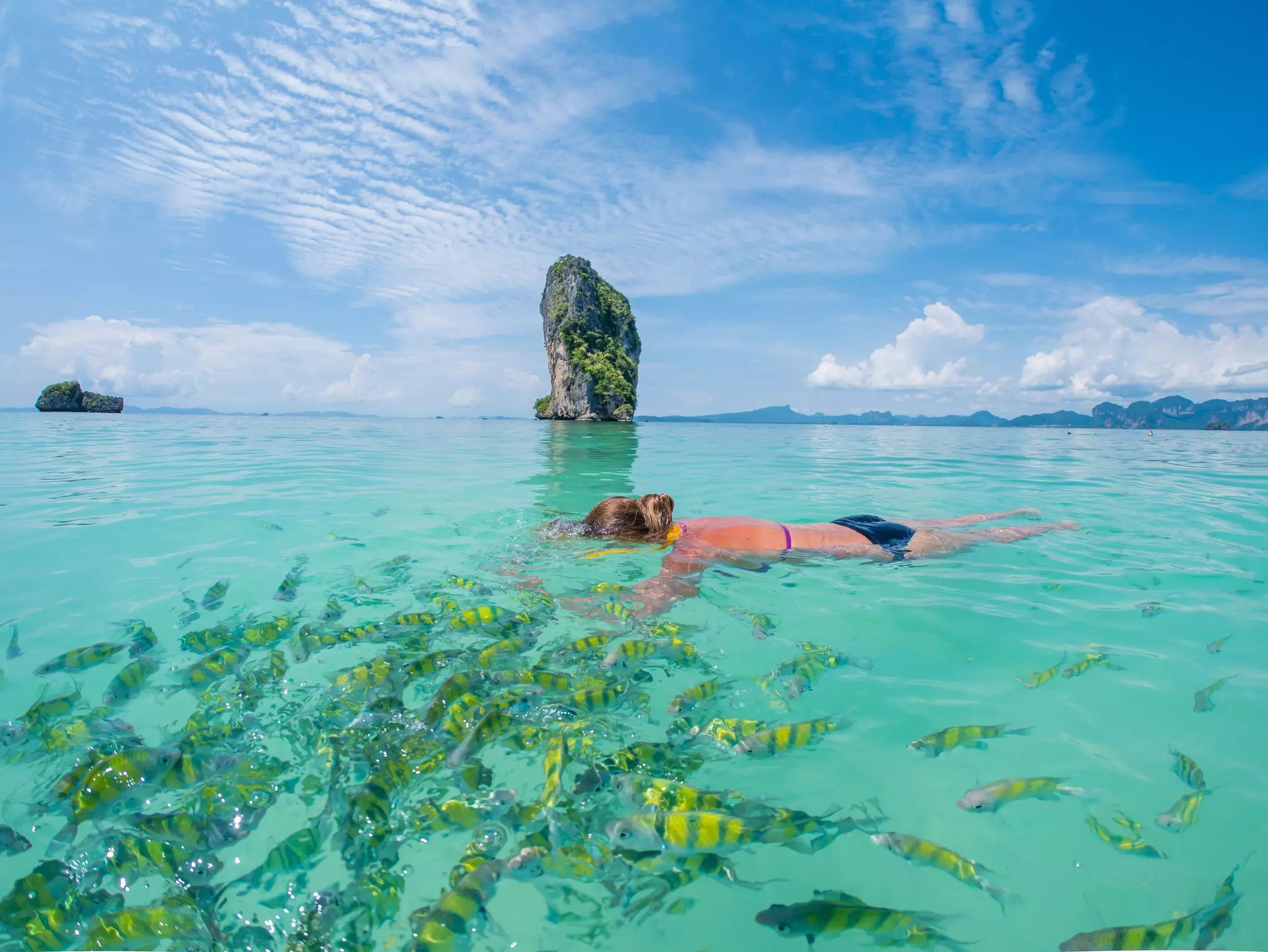 A woman snorkeling around the karst islands of southern Thailand. 