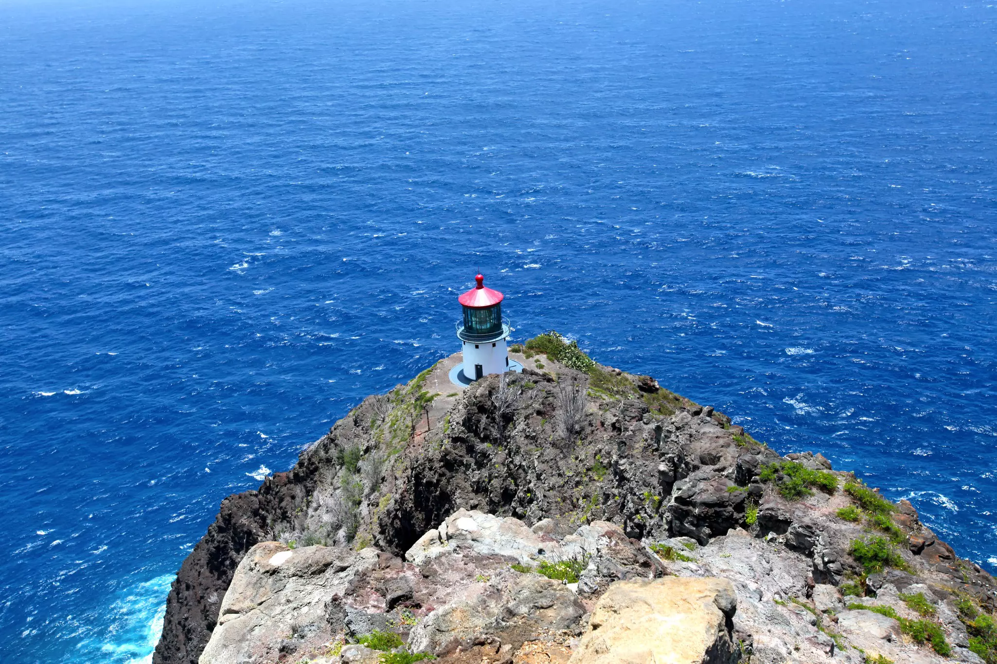 Shot looking down at Makapuʻu Point Lighthouse and the Pacific ocean on Oahu on a bright sunny Hawaiian day.