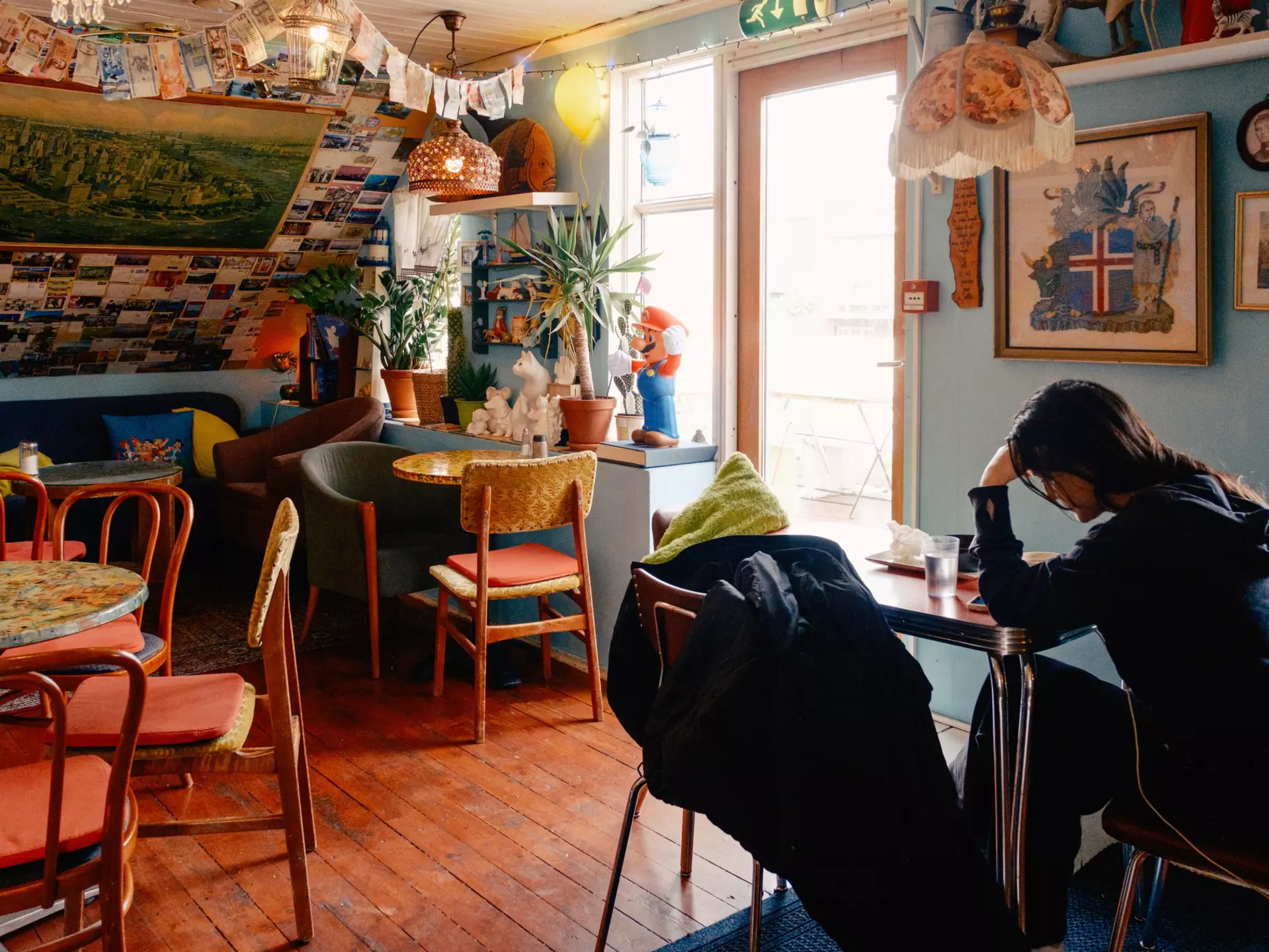 Tourist dining solo at Cafe Babalú, a quirky cafe in Reykjavik. Daniel Dorsa for Lonely Planet