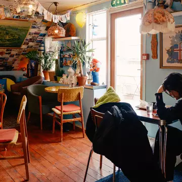 Tourist dining solo at Cafe Babalú, a quirky cafe in Reykjavik. Daniel Dorsa for Lonely Planet