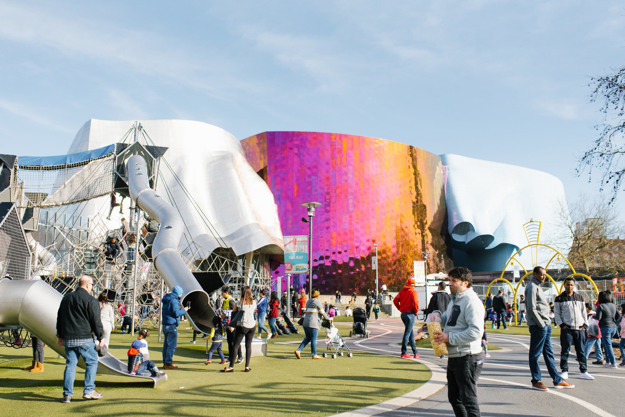 Visitors outside the Museum of Pop Culture and a children's playground