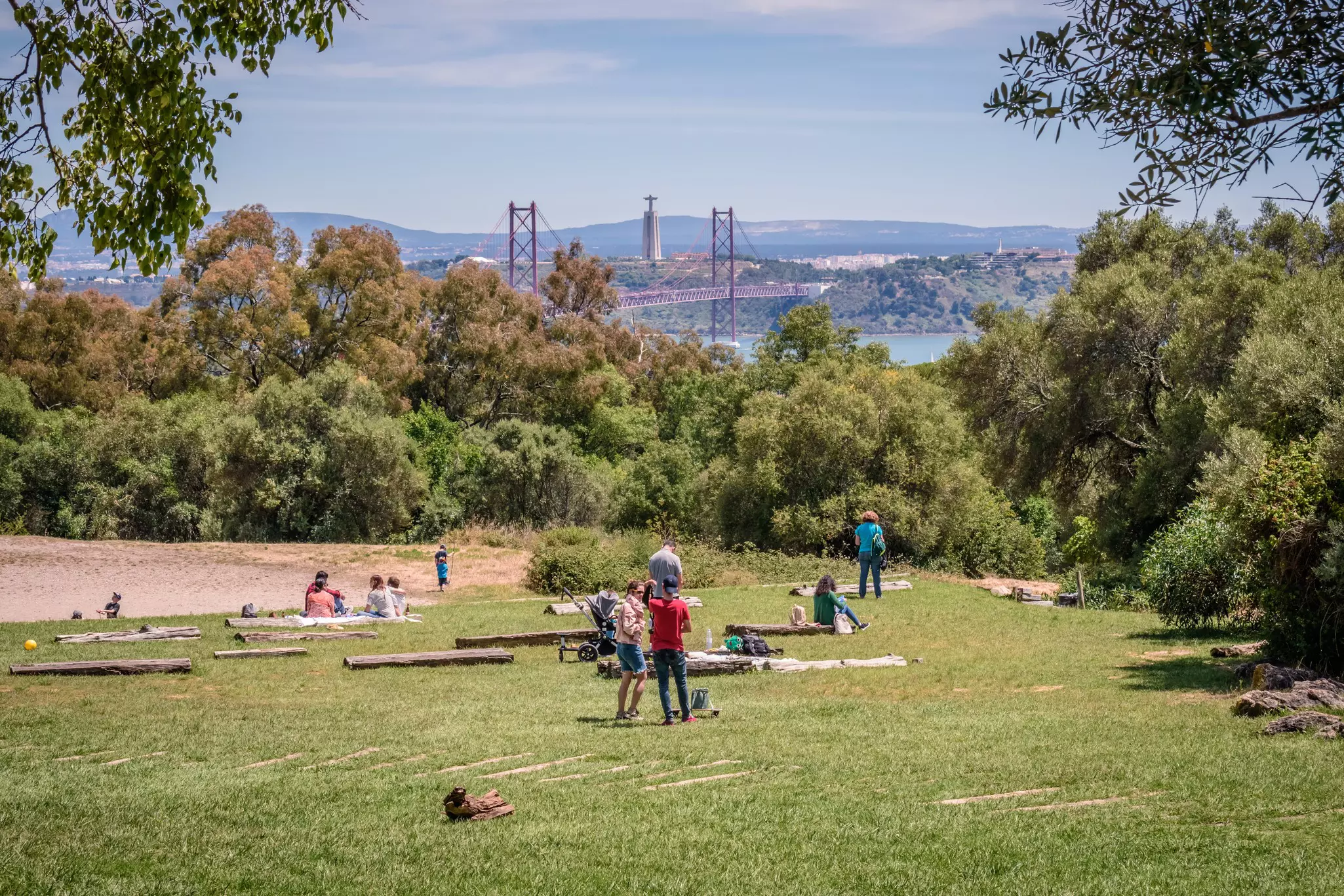 People play in parkland near a river.