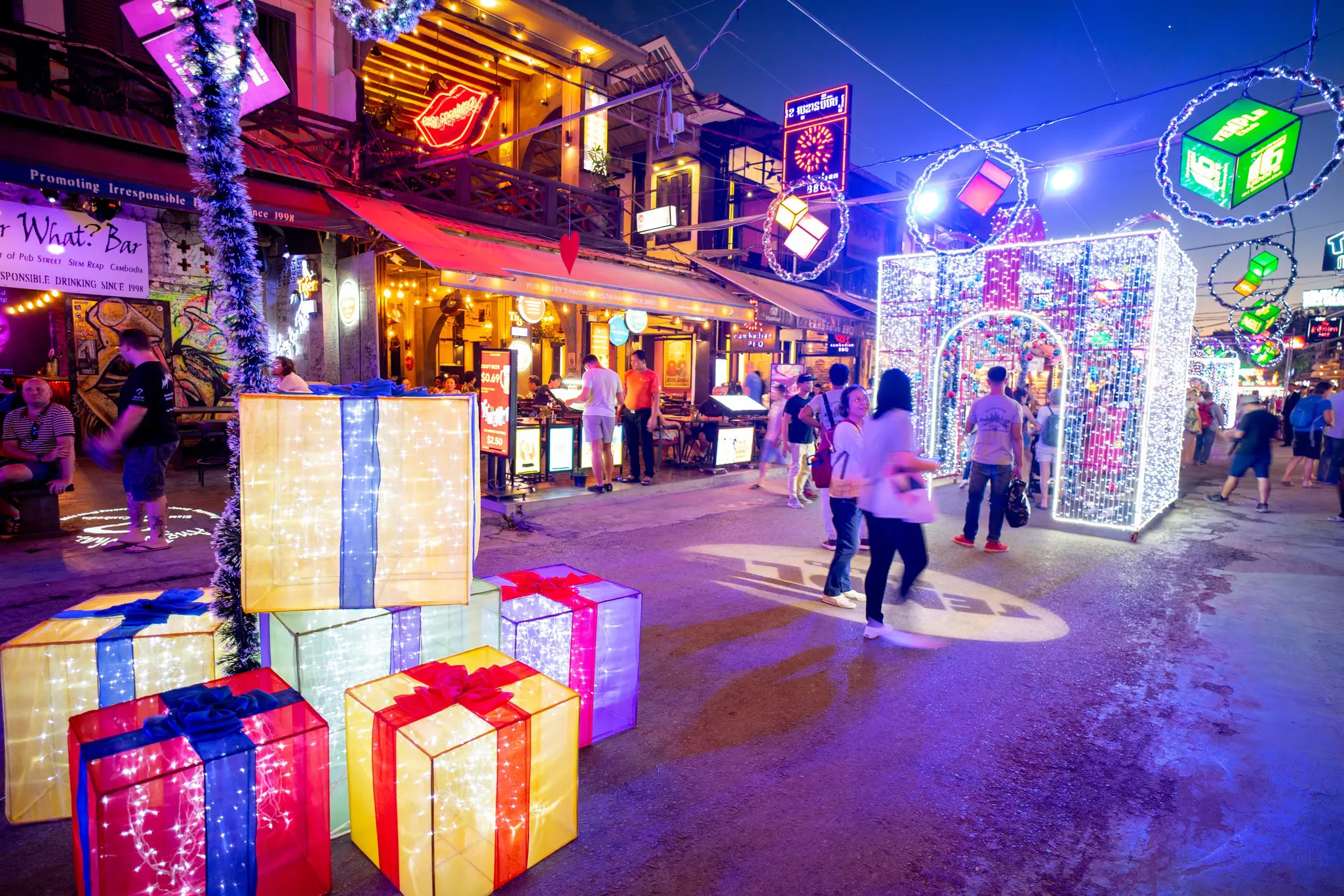 Large wrapped presents and light-filled archways create festive street decorations to mark Christmas.