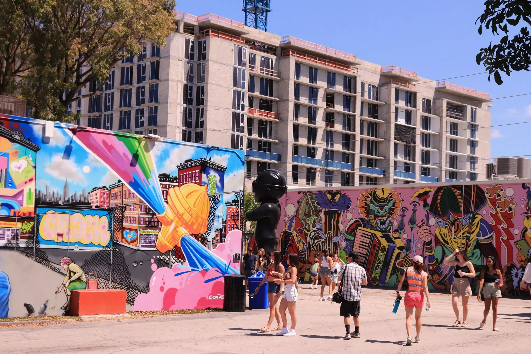 Tourists visit the graffiti murals and street art art Wynwood Walls Art and Design District in Miami
