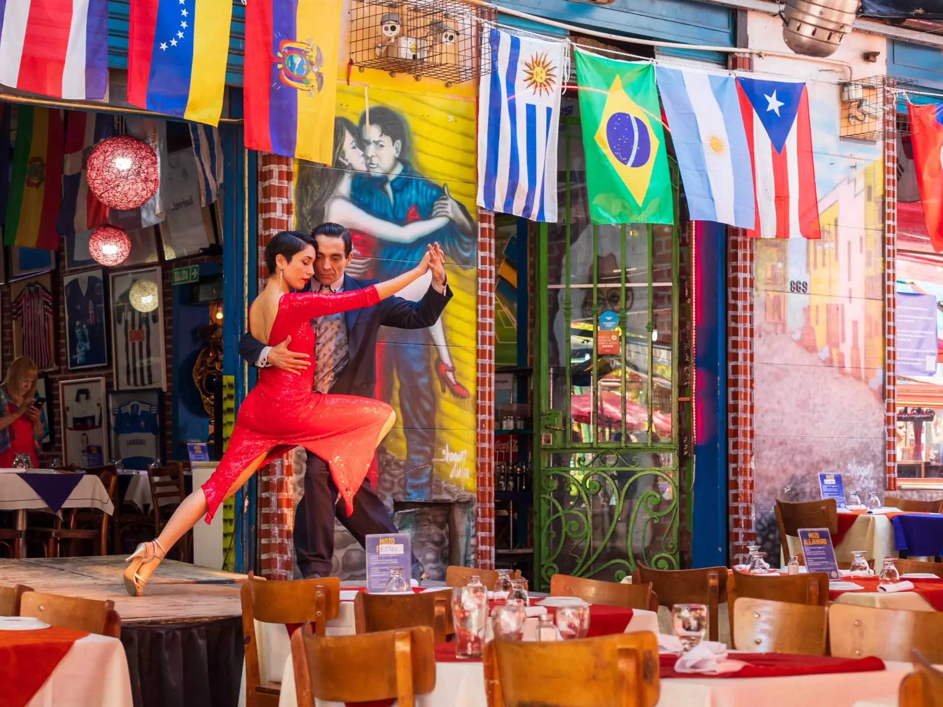 Two people tango on stage at a restaurant in Caminito