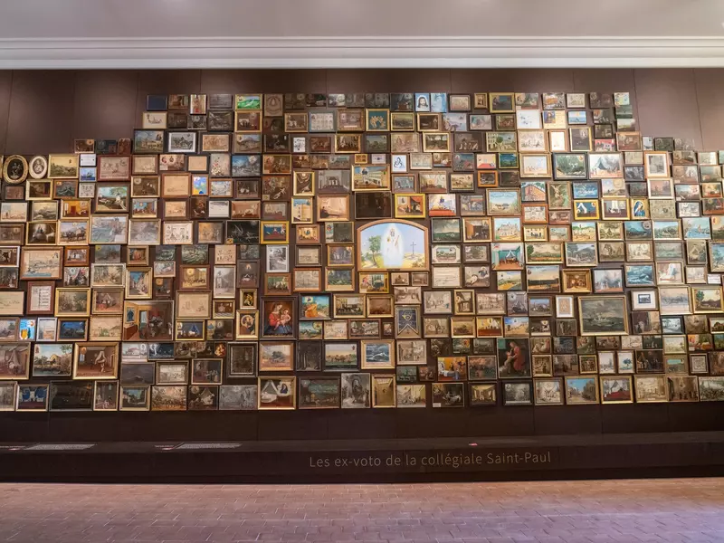 A wall entirely lined with framed artworks. 