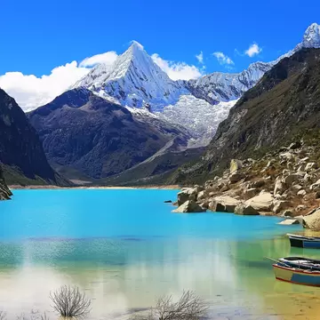 Wooden boats anchored on Lake Parón in the Cordillera Blanca, Peru