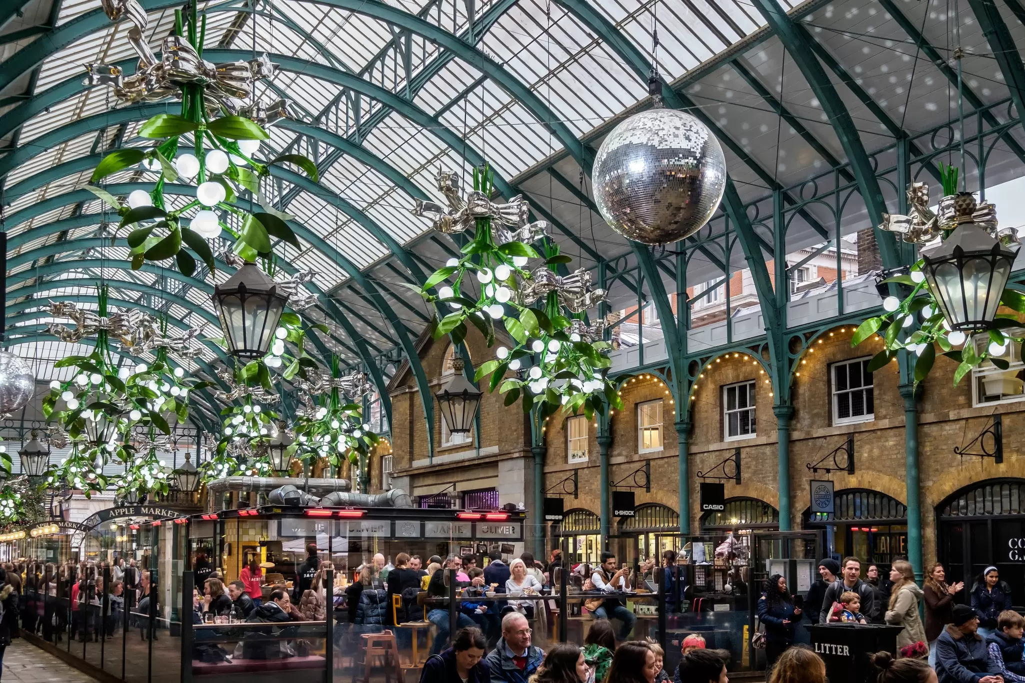 Christmas Decorations above shoppers at Covent Garden in London