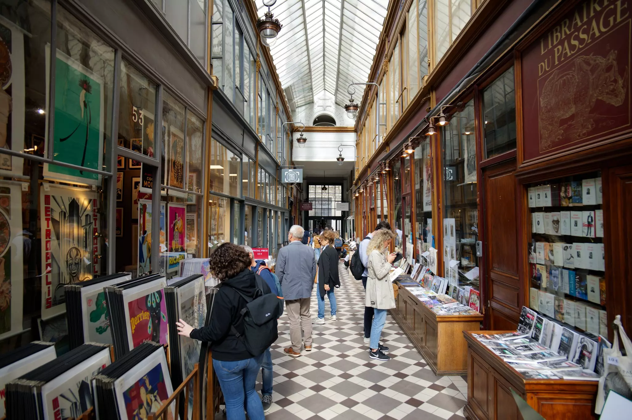 People enjoying and shopping at the famous Covered Passage des Panoramas in Paris, France.