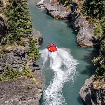 Tourists enjoying a high-speed boat ride on Shotover River near Queenstown, New Zealand.