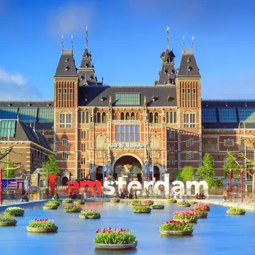 Rijksmuseum with tulips in Amsterdam..NOTE: dated image - "iamamsterdam" sign has been removed from outside museum.
Rijksmuseum, Amsterdam, North Holland, Netherlands, Benelux, Western Europe, Europe, travel, travel destinations, outdoors, daytime, museum, discovery, history, past, incidental people, long exposure, facade, building, architecture, fountain, water, water feature, colorful, flower, plants, text, tree, blue sky