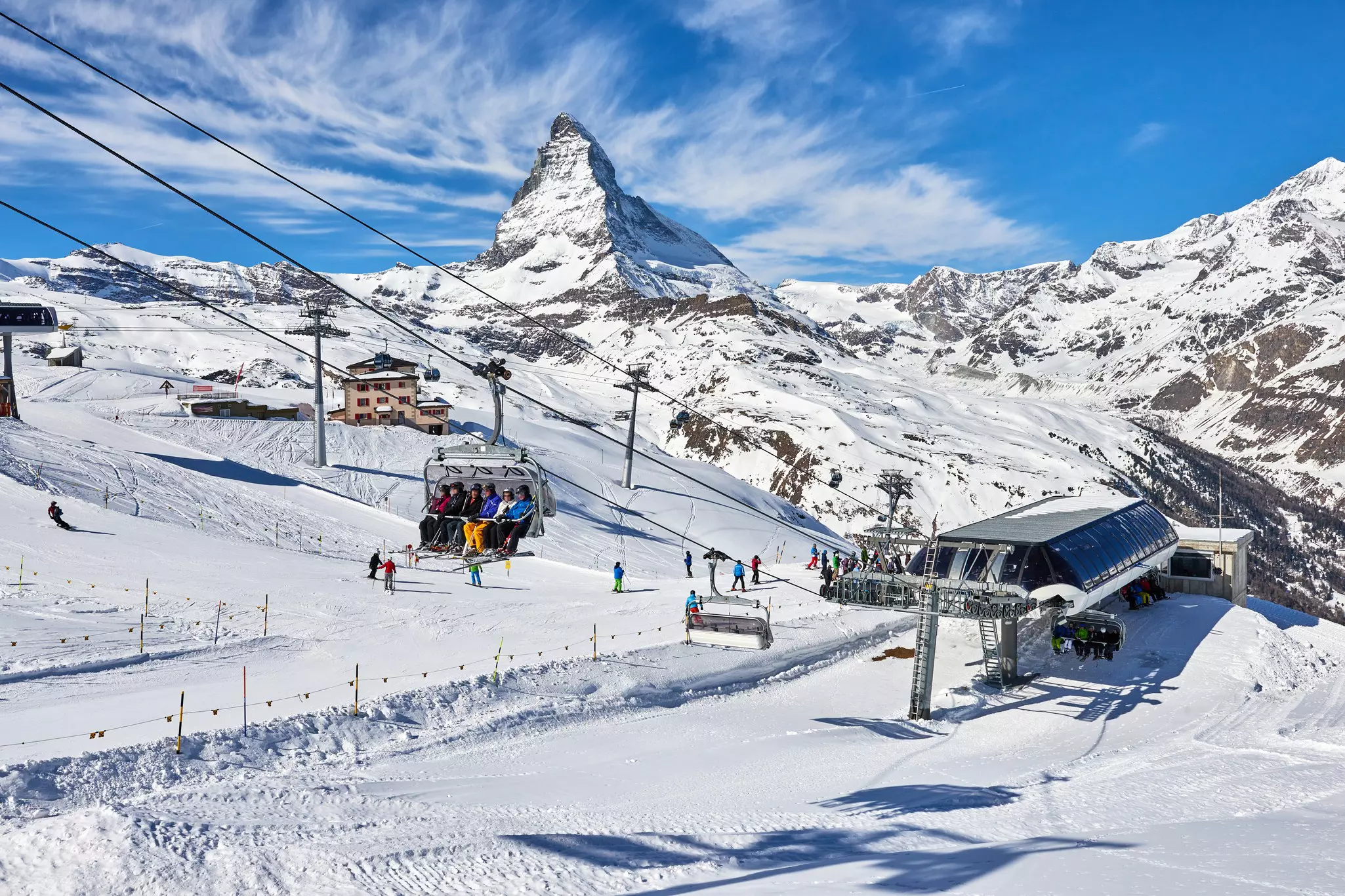 People are on chair lifts leaving a lift station, which has the Matterhorn in the background, in Zermatt, Switzerland.