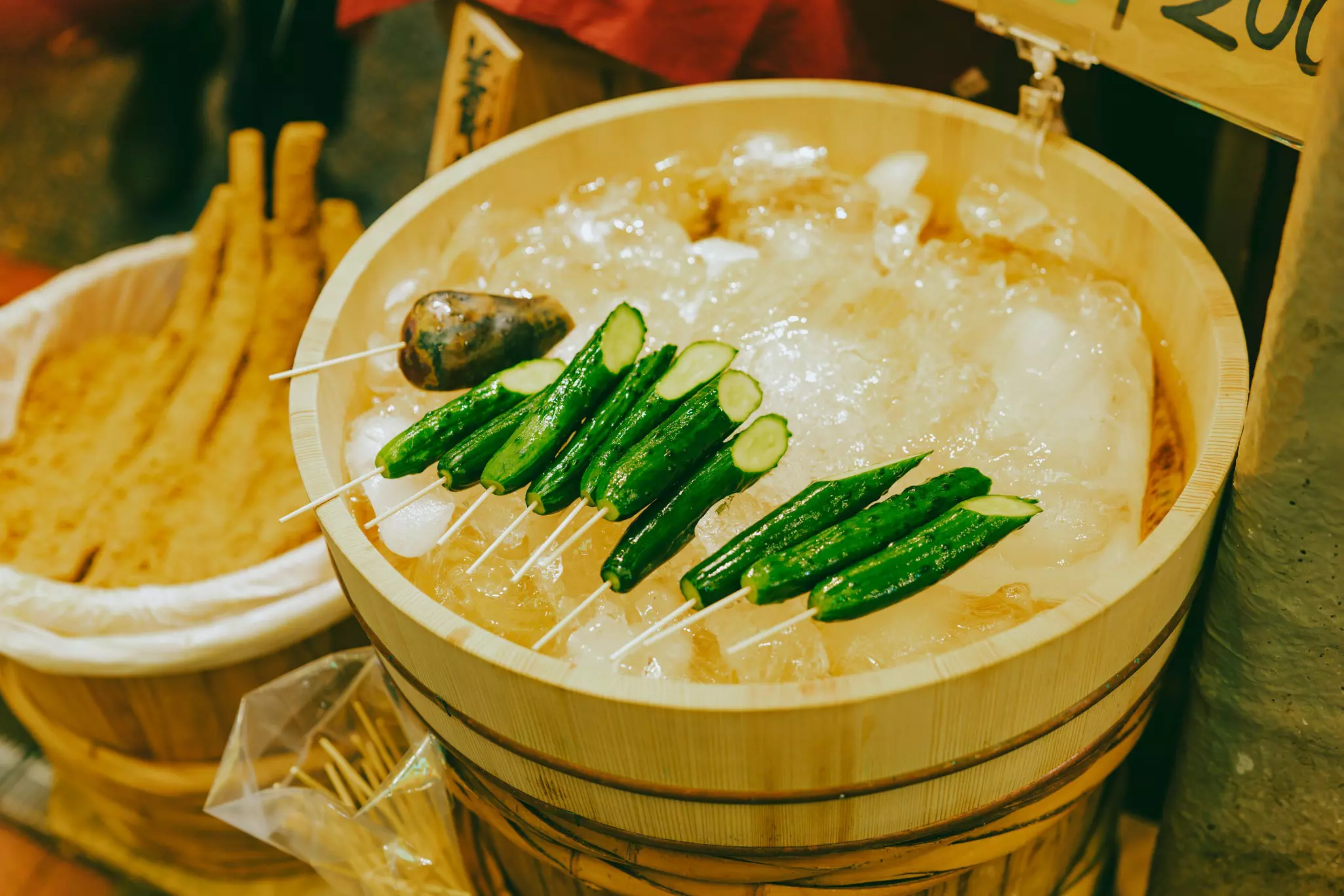 Skewers on ice and other foodstuffs in wooden barrels at Nishiki Market, Kyoto. 