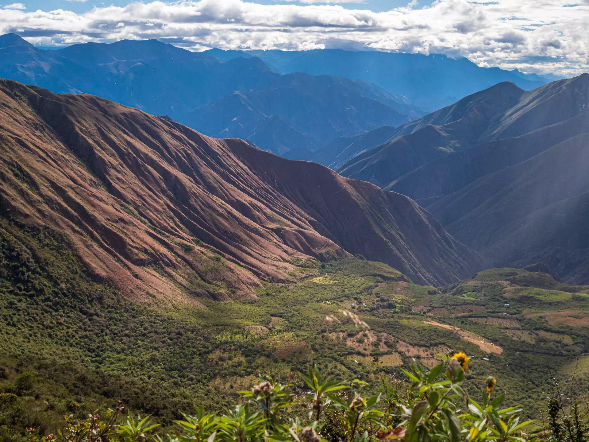 A mountainous area on a sunny day with blue sky and big clouds.
