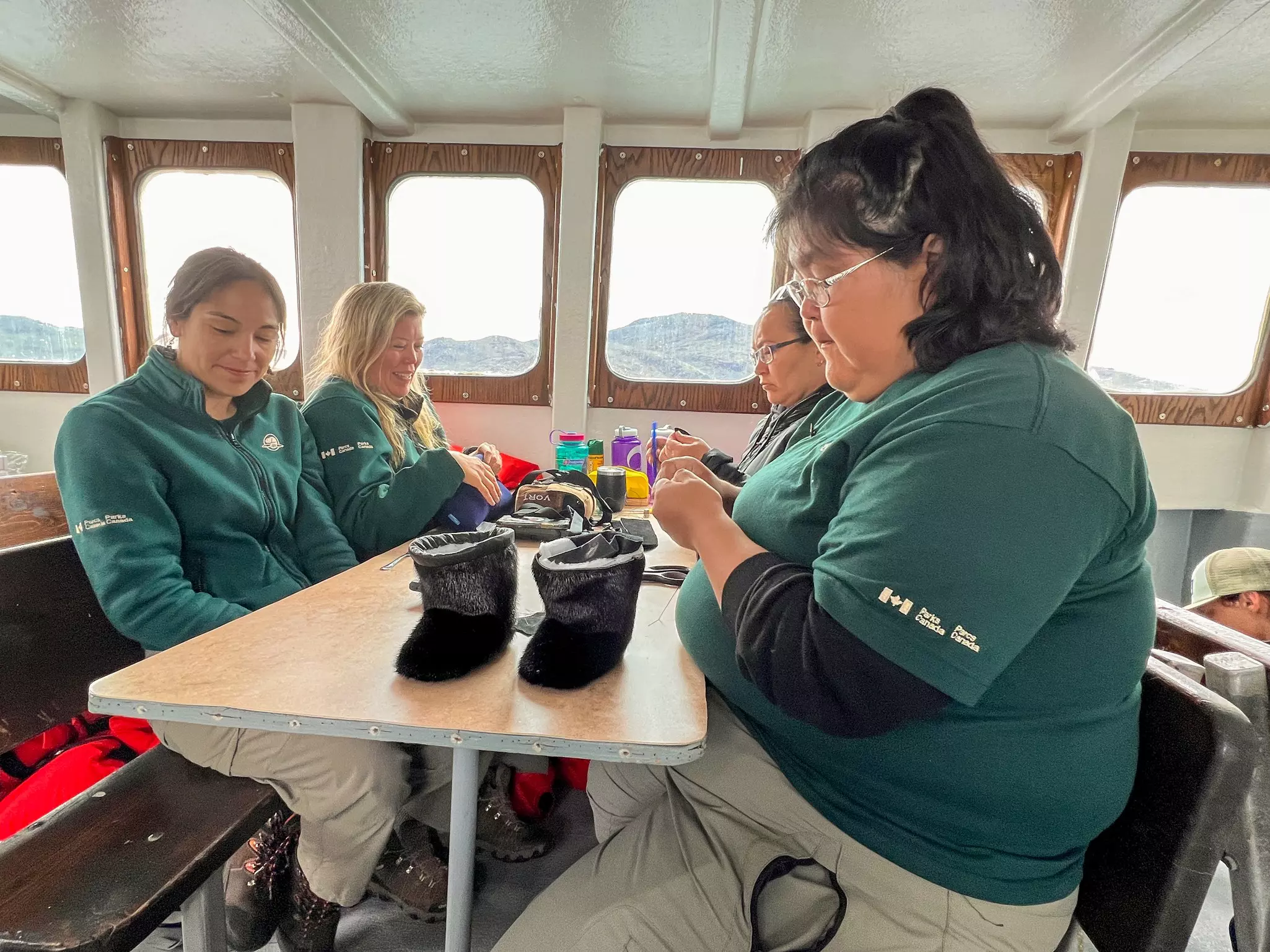 Parks Canada staffers sip tea and sew sealskin booties to pass the time on the voyage deep into the Torngat Mountains National Park © Liz Beatty