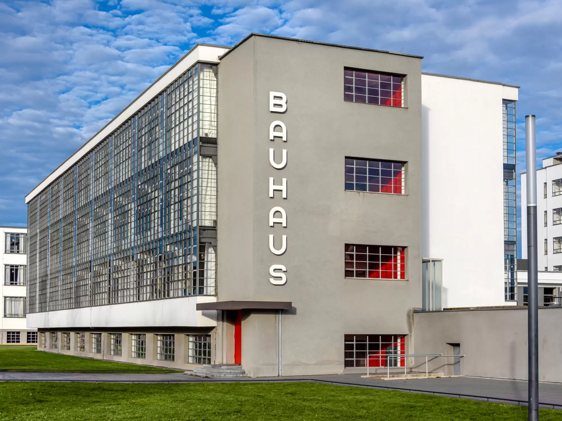 Grey, white and red-colored building with 'Bauhaus' written on the side 