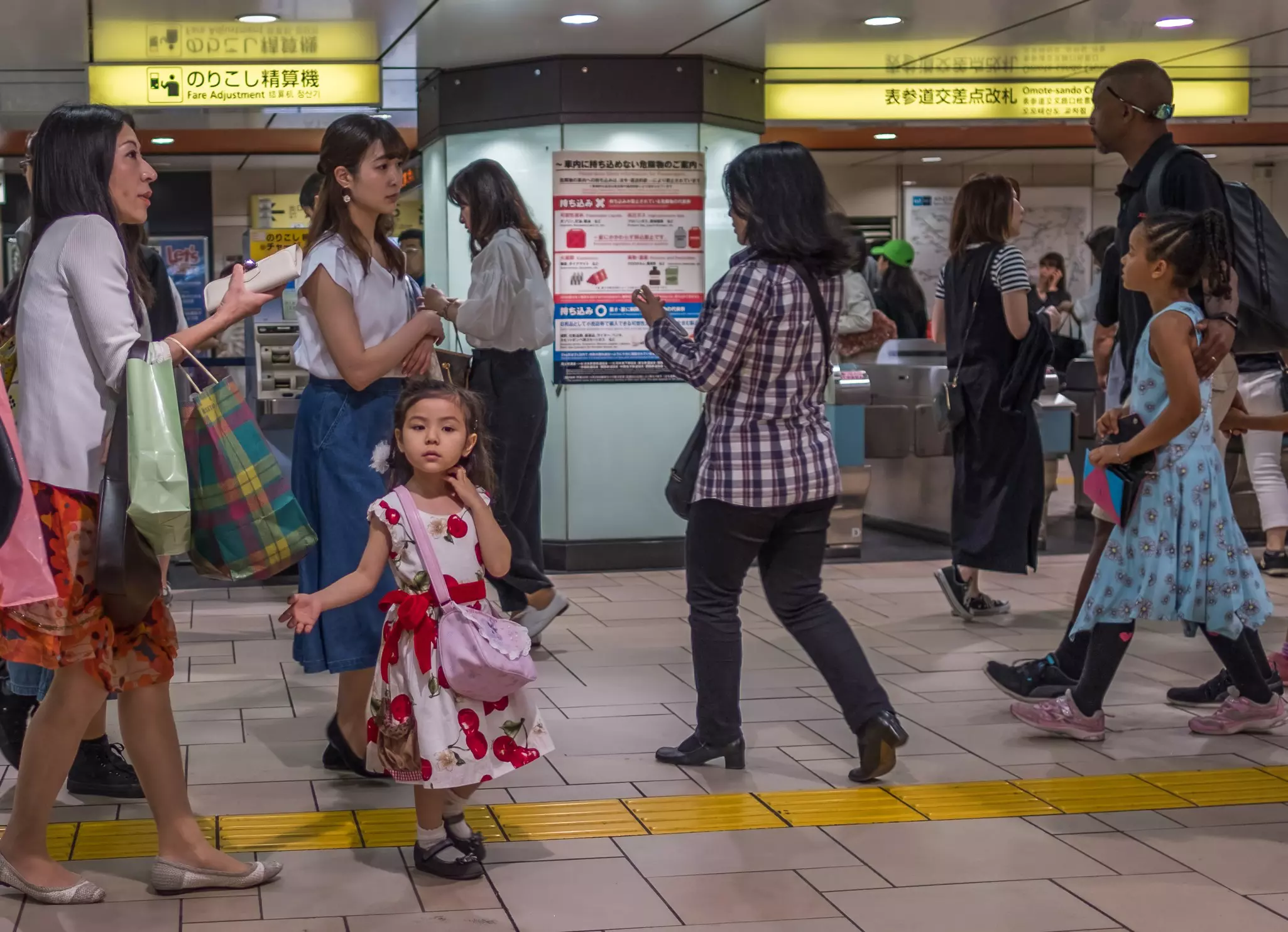 A mother and daughter are pictured in front of a ticket kiosk at an underground metro station.