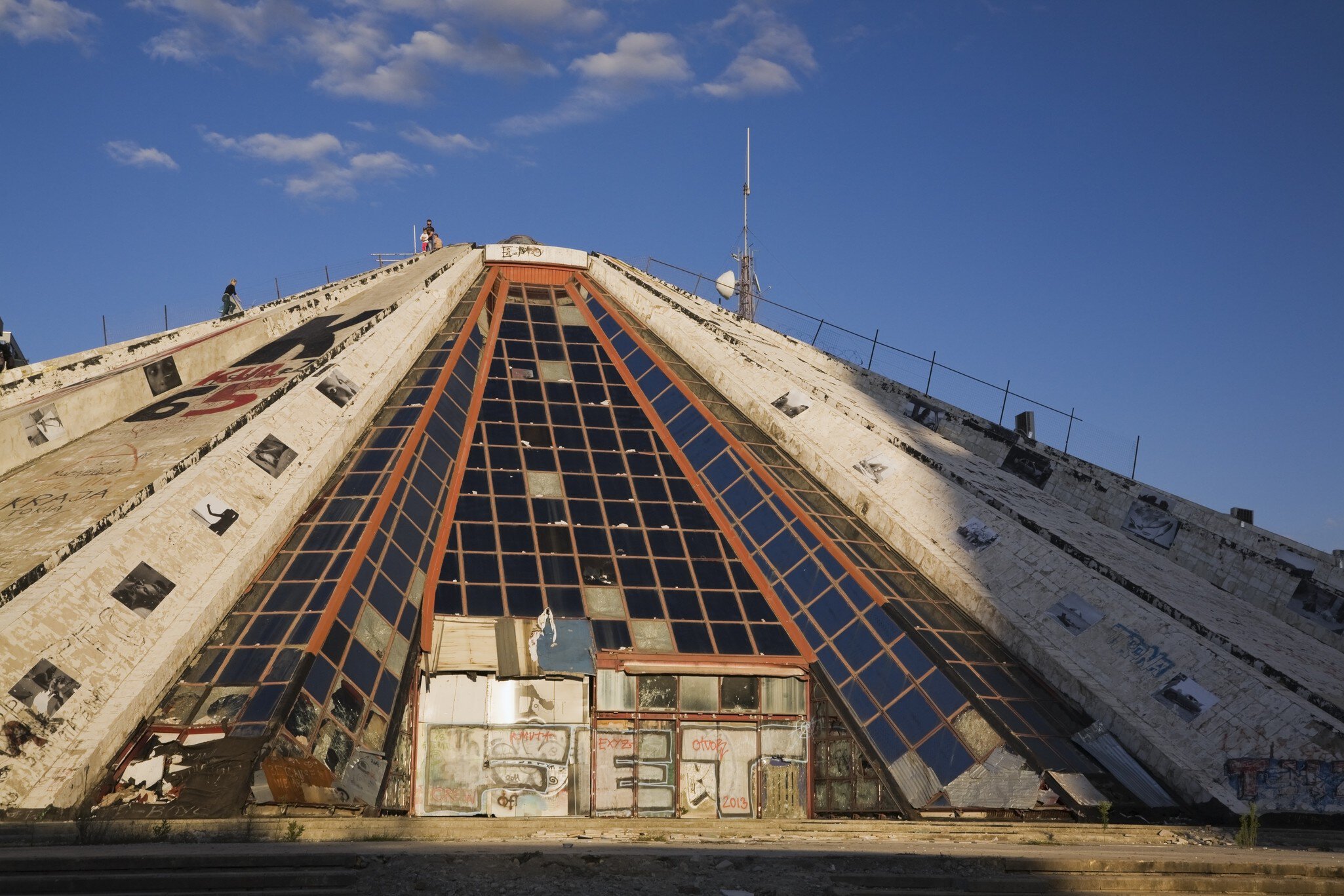 Adults and children climbing up the side of the Pyramid building that housed the former Enver Hoxha Museum, Tirana, Albania, Eastern Europe