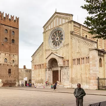 Tourists and passersby walk by the Basilica di San Zeno Maggiore  in Verona, Italy.