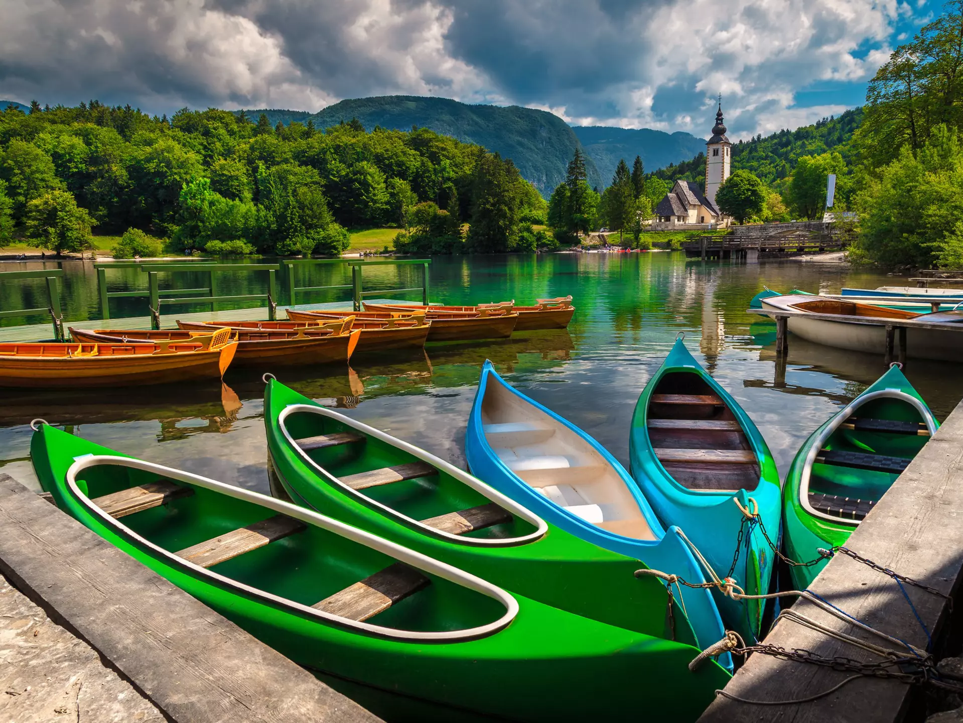 Anchored,Colorful,Canoes,,Kayaks,And,Wooden,Boats,On,The,Lake.
