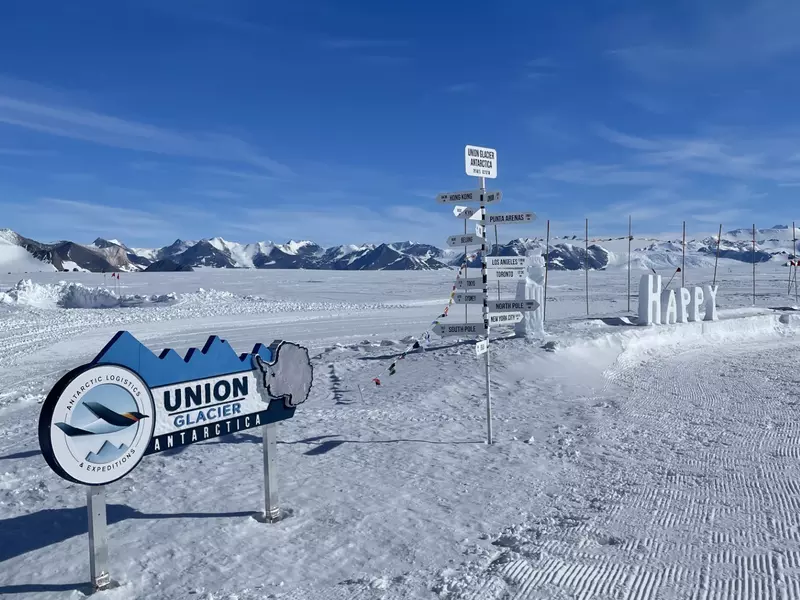 A series of signs in a snowy landscape pointing directions to different places on Earth