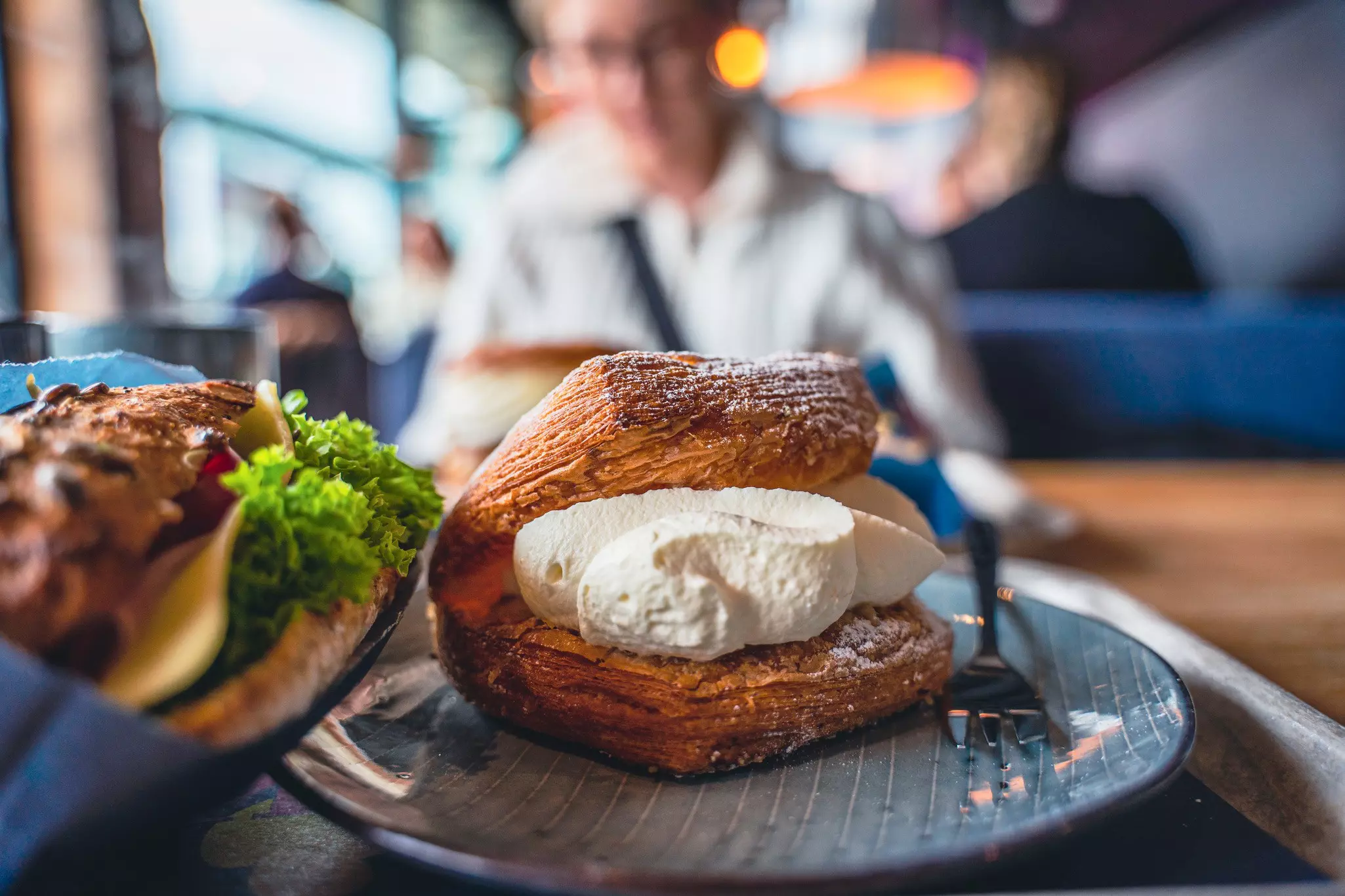 A large bun filled with whipped cream served in a cafe